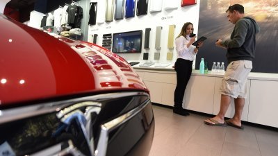 在去年3月位于美国加州的特斯拉汽车销售店，销售人员在替顾客下单预订电动车Model 3。