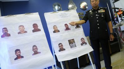 蔡义来向媒体展示11名通缉犯的照片，并呼吁 大众如发现这些人士，可向警方投报。（摄影：蔡开国）