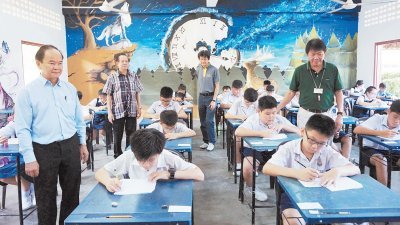 陈大锦（站者左起）、苏立兴、郑子明及潘德福，巡视华仁中学2018年度新生入学编班考试考场。