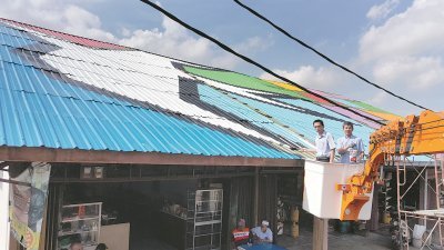 欧阳捍华（左）为老店屋顶上漆，为美化后的屋顶主持开幕，右是承包商雄健平。