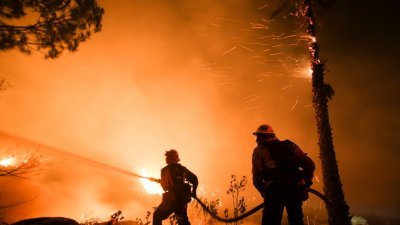 美国加州的圣保拉市在当地时间周一黄昏时段发生山火后，消防员努力灌溉灭火，但强烈的风势让山火迅速蔓延，并波及至文图拉县。