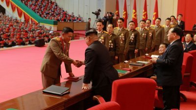 朝鲜最高领导人金正恩（左2）在军工大会上，表彰了洲际弹道导弹的研发人员。