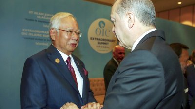 首相纳吉（左）周三在伊斯坦布尔出席伊斯兰合作组织特别峰会时，与土耳其总统埃尔多安握手。