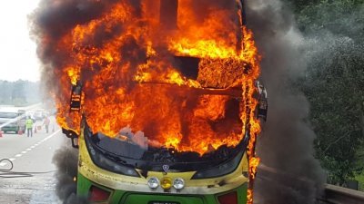 双层巴士因故障而被迫停放在紧急车道，随后失火燃烧，现场可见火势猛烈，冒出浓烟。