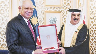 纳吉（左）周五在巴林王宫，从巴林国王哈马德手中接过该国的最高等勋章“哈马德国王发展勋章”。