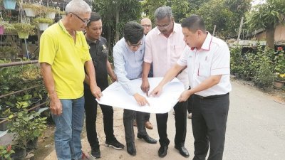 黄田志（右）与加影市议会官员和当地居民商讨峇拉路交界处的提升工程，并于本月动工，预计花费百万令吉。
