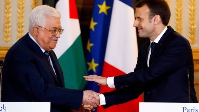 法国总统马克龙（右）周五在爱丽舍宫，和巴勒斯坦自治政府主席阿巴斯会晤。马克龙在会后的记者会上，与阿巴斯握手，给予支持。