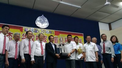 在骆保林（左4起）陪同下，刘子健颁发首长杯常年杯给槟城恒毅校友会会长方志伟。