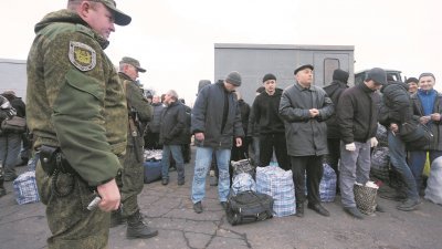 乌克兰政府与乌东部民间武装，周三进行了自冲突以来最大规模的战俘交换。图为沦为战俘的乌克兰军人，在戈利夫卡市附近的检查站，等候进行战俘交换。