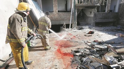 阿富汗首都喀布尔的《阿富汗之声》办事处，与什叶派文化中心周四遭到自杀式攻击，造成伤亡惨重，现场一片颓垣败瓦，图为消防员在清理地上的斑斑血迹。