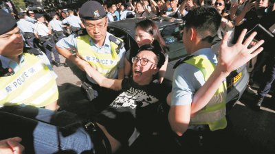 泛民主派人士周六游行，遭到爱国人士阻扰，双方发生争执，警方随后将社会民主连线主席吴文远（图）等人带走。