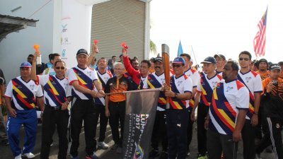 槟州总警长蔡义莱（左3）周一上午为东运会火炬行主持挥旗礼，首棒代表聂阿里（右）为火炬行领先开跑。