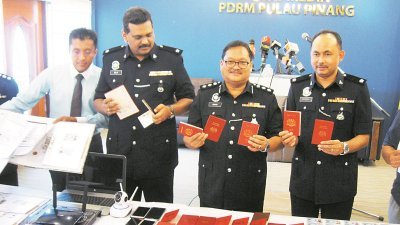  阿都甘尼（左3）展示警方充公的护照、文件及身份证。