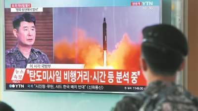 韩美周三进行联合训练，以表明韩美同盟不会容忍朝鲜的挑衅。这是一名韩国士兵周二在首尔观看朝鲜试射洲际导弹的报导。
