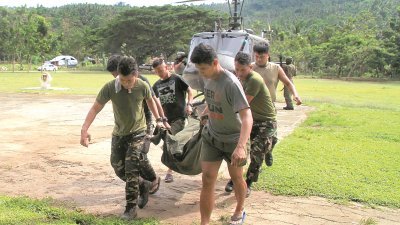 菲律宾军方在马拉维打死300多名恐怖分子，但也牺牲了80军警。这是菲律宾士兵将一名殉职同僚的遗体，抬下直升机。