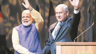 印度总理莫迪（左）周三在特拉维夫会展中心，会见当地的印度后裔，以色列总理内塔尼亚胡陪同出席，两人在台上握手，并向现场人士举手致意。