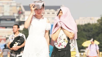 北京周一迎来“上蒸下煮模式”，最高气温达到36度，游客冒酷暑游览天安门广场。 