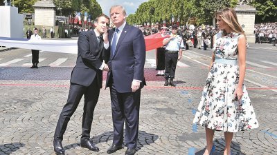 法国总统马克龙（左）和美国总统特朗普，在周五的阅兵结束后握手道别，两人继5月握手较劲后，这次握了29秒。