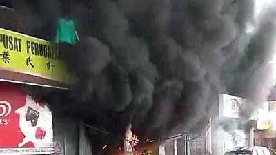 失火的修车厂，火势不但猛烈且冒出滚滚浓烟，附近的店家也为了安全起见，纷纷紧急撤离。