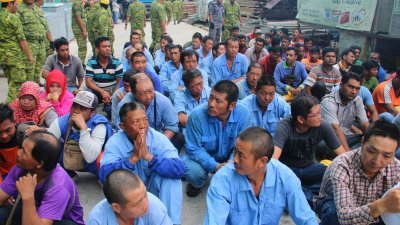 一律穿上蓝色制服，皮肤白皙的中国籍劳工在一堆外劳中较为显眼。