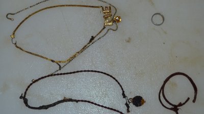 警方在死者身上找到金链、银链、银色戒指、平安绳，以及LOVE字和心型的炼牌。