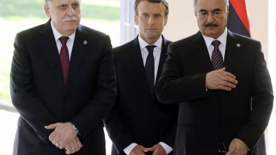 利比亚民族团结政府总理萨拉杰（左）和军事强人哈夫塔尔（右），当地时间周二在巴黎达成共识。促成两人 会晤的法国总统马克龙，站在两人之间。