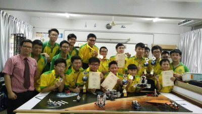 峇株巴辖高级中学学生在机器人赛事中，荣获多项大奖，成赛会大赢家。梁顺智（前左）与获奖学生分享喜悦。