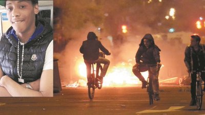 伦敦黑人青年查尔斯（小图）被警员摔死，引发民众到伦敦东部多尔斯顿的事发地点示威，却演变成暴力行动。街上堆放了物件被纵火焚烧，一些骑著脚车青年，在街上来回骑行。