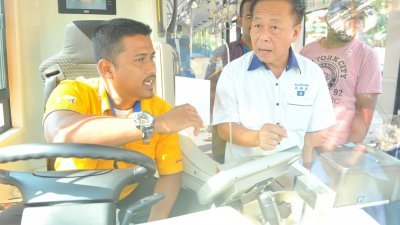 刘新金（右）周一前往蕉赖美嘉花园巴士站，了解捷运公司旗下接驳巴士的运行情况，并向巴士司机探问乘客量和路线相关的问题。 （摄影：陈为康）