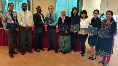 亚洲医药大学副校长玛里姆都（左3起）颁发表扬奖给尢再华博士、李慧雯（左6起）、黄馨娴和其他受表扬者。