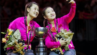 丁宁（左）第五次打进女双决赛后，终于首尝女双世界冠军滋味；她与拍档刘诗雯在颁奖仪式上玩起了自拍。