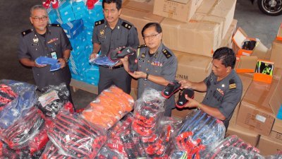 霹雳贸消局执法人员取缔赝品，起获2764双著名品牌鞋子的仿制品，左起是奥斯曼、阿末阿拉祖丁及苏海米。