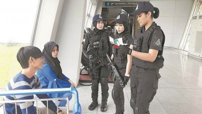 英姿飒爽的黑衣女特警在机场持枪巡逻，细心查问。