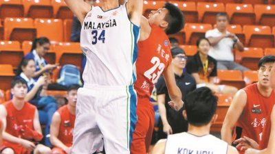 重返大马男篮队怀抱的“轰天柱”陈利伟（左），成功在台湾师范大学球员简家暐手中，抢获篮板球。