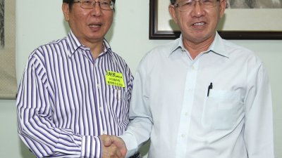 刘利民（左）与沙巴华文独立中学董事联合总会主席拿督杨菊明握手，欢迎沙巴董联会回归董总。（摄影：张真甄）