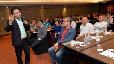 黄伟（左）在2017互联网金融商战传统企业救星课程上，向在场数十名企业家灌输创新商业模式。前右为《东方日报》执行总编辑陈利良。 （摄影：曾钲勤）