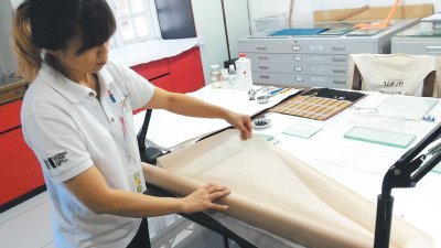 李妍霓展示的是富含纤维的楮纸（Kozo Paper)，这是修复破损纸张的重要材料。