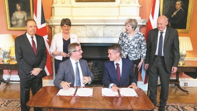 英国首相特丽莎梅（后排右2）与北爱民主统一党党魁福斯特（后排左2），周一在唐宁街首相府见证两党签署合作协议。