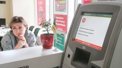 乌克兰金融机构周二遭网络攻击，银行员工守在一台显示故障的支付终端机旁。
