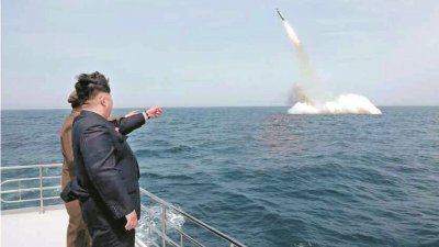 朝中社2015年5月9日发布照片，报导朝鲜最高领导人金正恩（黑衣者），观摩朝鲜战略潜艇从水下试射弹道导弹过程。