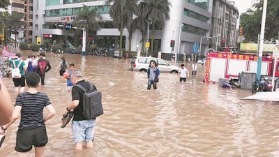 广州周日广泛地区3小时已录得100毫米以上降雨量，街道积水高至小腿位置，市民被逼涉水而行。