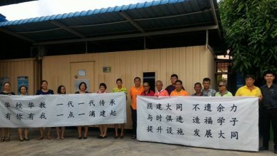 何伟强（左8）、黄惠坤（左12）与建委会、老师、家协们拉著自制宣传布条，呼吁各界支持大同小学重建校舍。