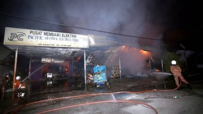班达马兰6间商店连环烧，消拯员在奋力灭火。