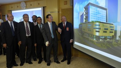 林冠英（左5起）与林尤丰一起观看槟榔医疗城计划的模拟建筑物。左为法力占。（摄影：蔡开国）