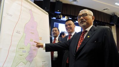 莫哈末哈欣（右）周五宣布埔奕州议席补选日期，并向媒体展示埔奕选区地图。