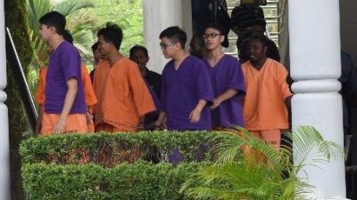 身穿紫色扣留服的李宗圣及两名助理周六早上被押往大山脚法庭，但并没进行延扣手续。