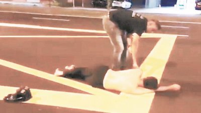 视频截图显示，大叔赤裸上身以大马路为床，吓坏旁人立刻上前把他叫醒。