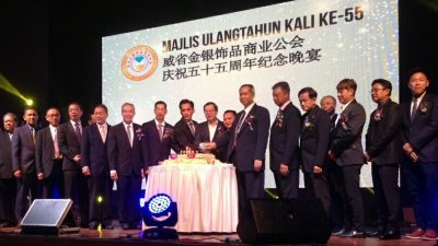 冯翰民（左5起）、林峰成、陈伟华及林冠英（左10）等嘉宾集体切蛋糕庆祝威省金银饰品商业公会55周年纪念庆典。