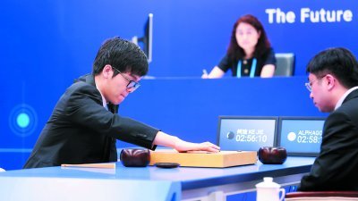 世界第一棋手柯洁（左）周二在浙江省乌镇与AlphaGo首场对决，第七手用“进三三”下法跌破众人眼镜。-路透社- 
