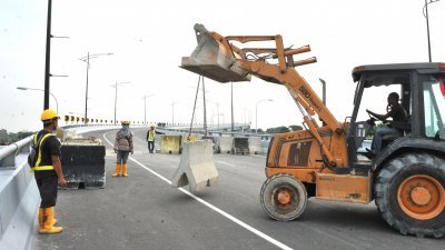 雪州公共工程局出动挖泥机将石墩移走，以便巴生第三大桥能通车。（摄影：邱继贤）